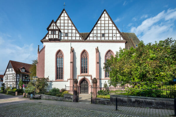 Kirche eher in einer Klosterform ohne klassisches Kirchendach kleinem Vorgarten und Zaun