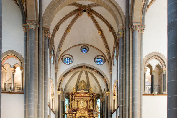 Kirchenschiff mit Altar und großem Heiligtum im Mittelpunkt, mehrere Bänke