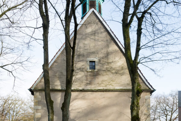 Kapelle von Außen mit schlichter Farbe und türkisen kleinen Turm