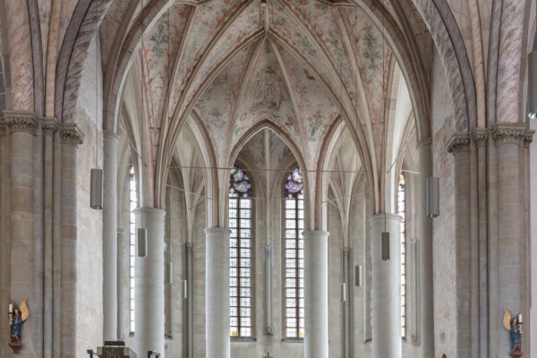 Altar einer Kirche mit hoher Decke vier großen Säulen im Hintergrund und einer kunstvoll inszinierten Decke