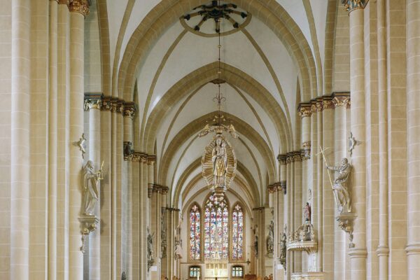 Großer Abschnitt der Kirche mit vielen Bänken und ganz vorne dem Altar