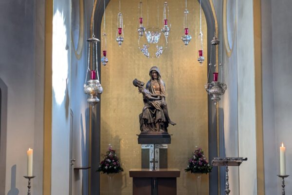 Schrein mit heiligen mit Jesus im Arm umringt von von der Decke hängenden Kerzen