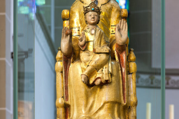 Heilige Walburga mit Kind dargestellt Kirche Hand erhoben mit Handfläche nach vorne und goldenem Gewand auf einem Thron sitzend